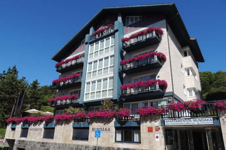 Fachada de los apartamentos en verano, con los balcones decorados con flores
